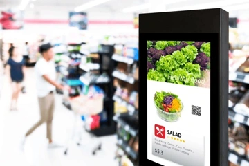 Digital display advertising a salad with ingredients and price in a grocery store.