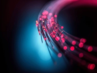 Close-up of illuminated fiber optic strands with red and blue lights.